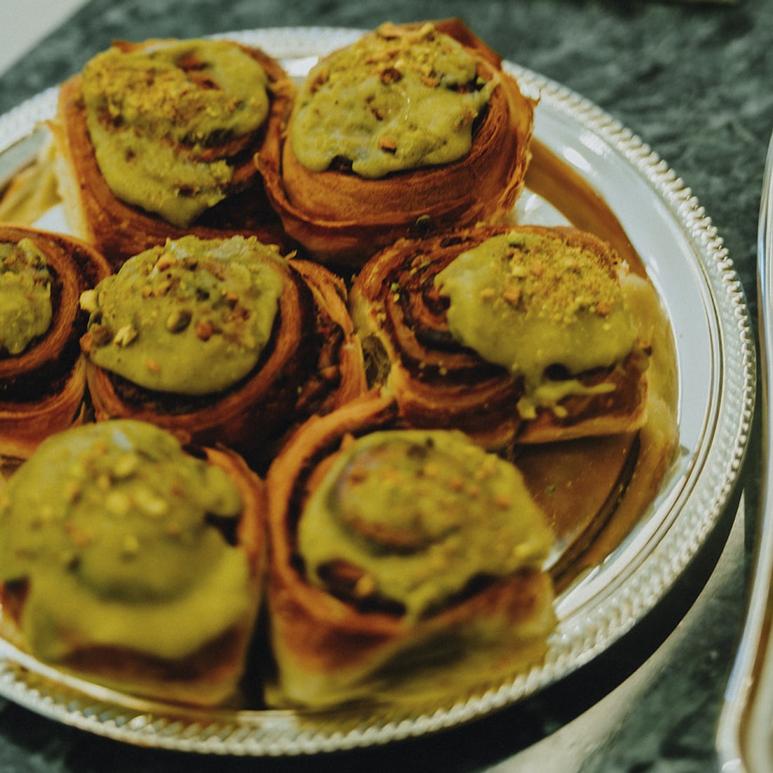 A silver tray of pistachio-glazed rolls