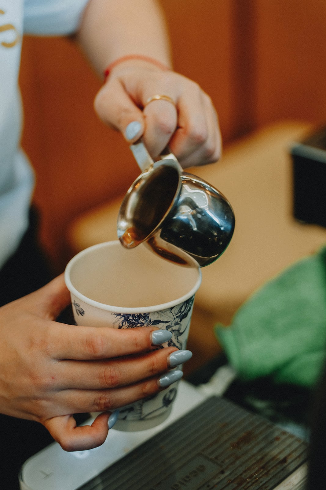 A Wolfmoon barista pouring steamed milk into a cup